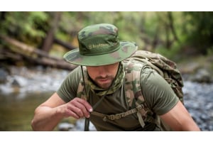 a man climbing with camouflage cloths and boonie hat