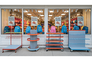 an inviting storefront with holiday season banners and in front displays and racks