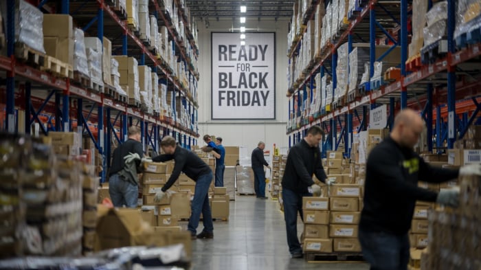 busy workers in warehouse preparing for black friday