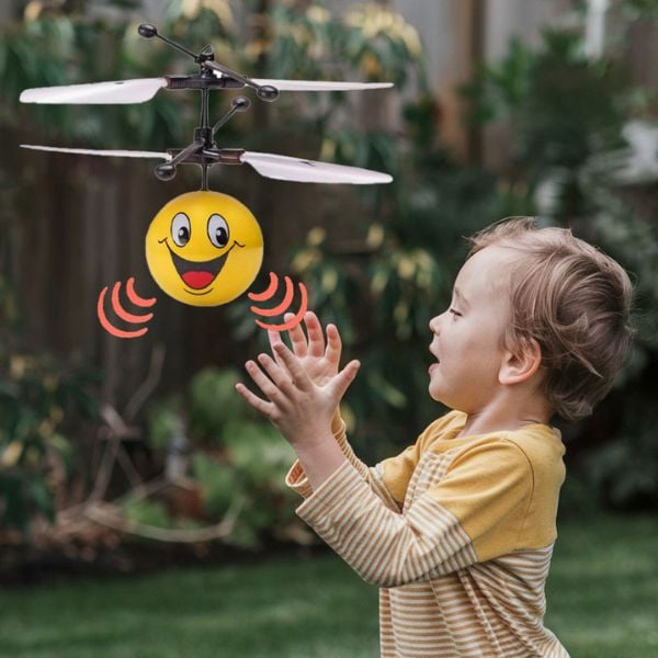 a photo of a boy playing with a yellow flying toy