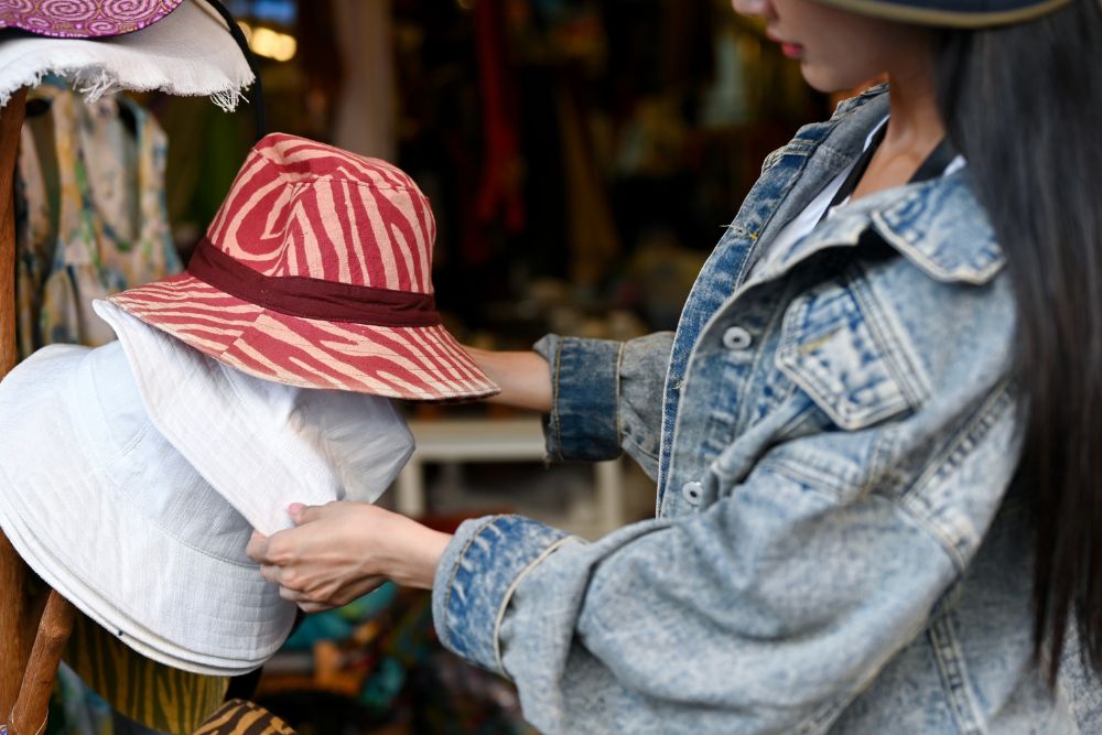 a woman selecting a bucket hat for her style