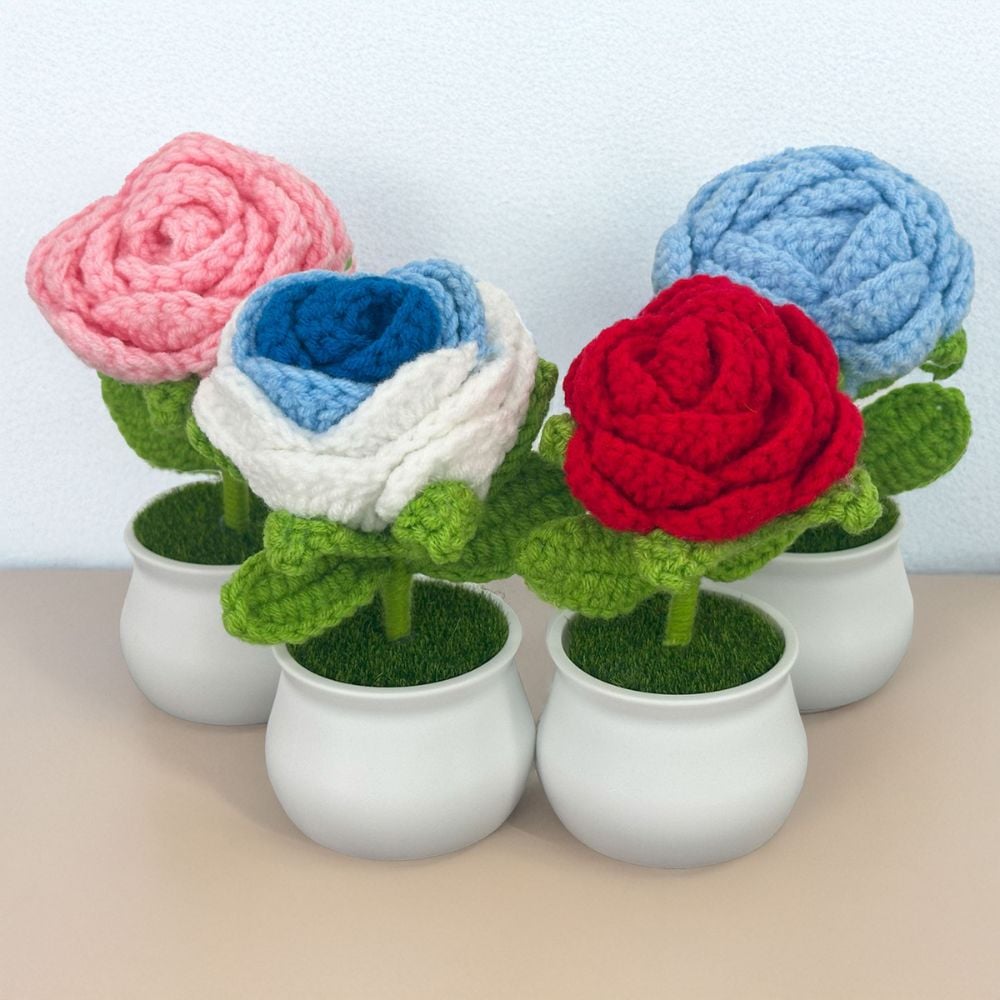 colorful crochet roses in pot on a table