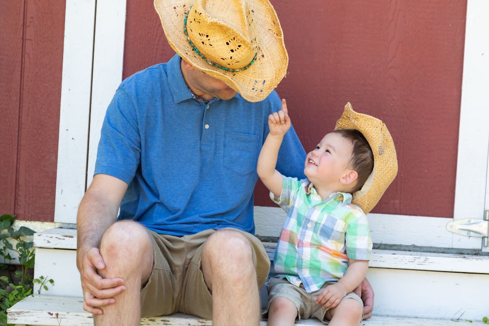 dad and son wearing a straw cowboy hat and enjoying time together