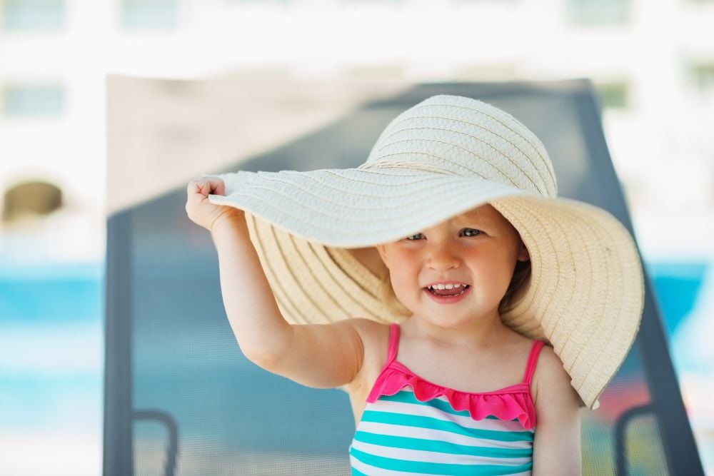 a kid wearing an oversized summer hat